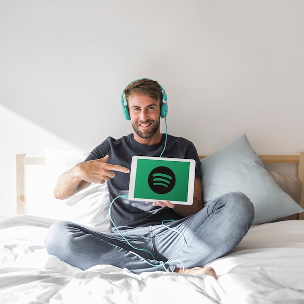 Hombre joven sosteniendo tablet con la app de spotify