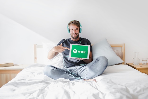 Hombre joven sosteniendo tablet con la app de spotify