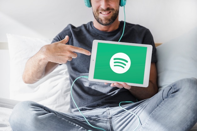 Hombre joven sosteniendo tablet con la app de spotify