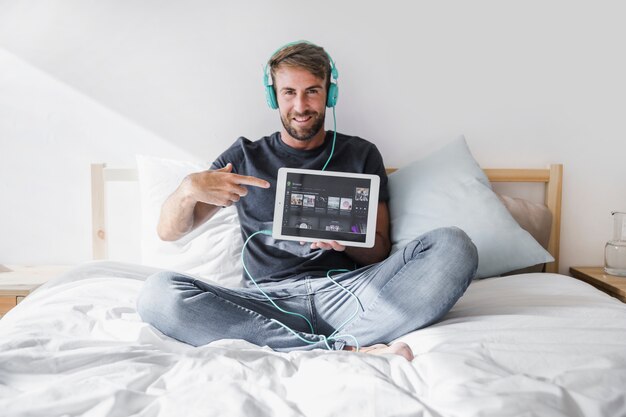 Hombre joven sosteniendo tablet con la app de spotify