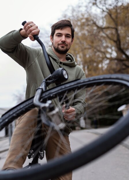 Hombre joven con su bicicleta en el parque