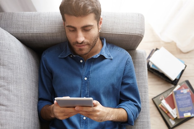 Hombre joven con tableta en casa