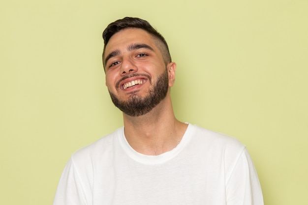 Foto gratuita un hombre joven de vista frontal en camiseta blanca amplia sonriendo