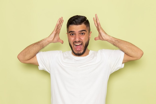 Foto gratuita un hombre joven de vista frontal en camiseta blanca gritando