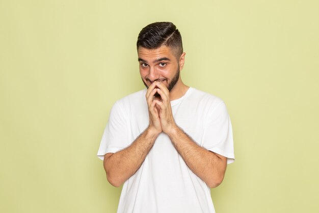 Un hombre joven de vista frontal en camiseta blanca posando