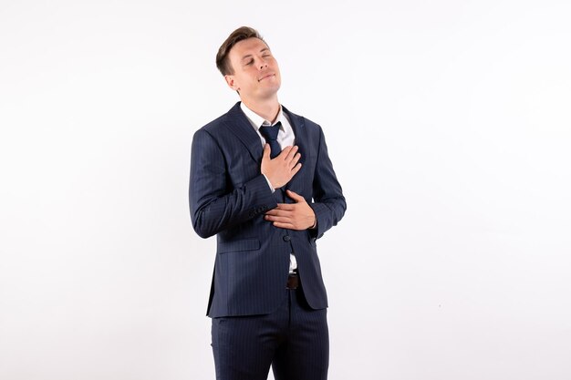 Hombre joven de vista frontal posando con expresión encantada en elegante traje clásico sobre fondo blanco.