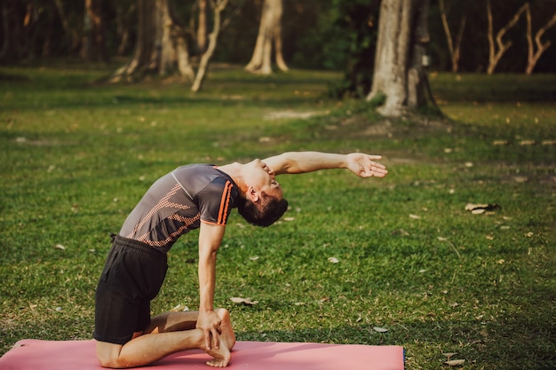 Foto gratuita hombre joven, yoga y naturaleza