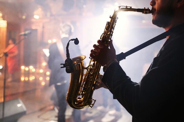 El hombre juega con un saxofón