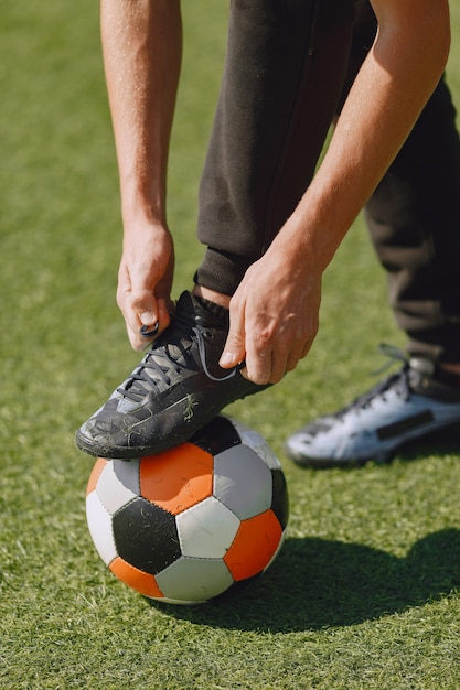 Foto gratuita el hombre juega socerl en el parque. torneo de mini-fútbol. chico en trajes deportivos negros.