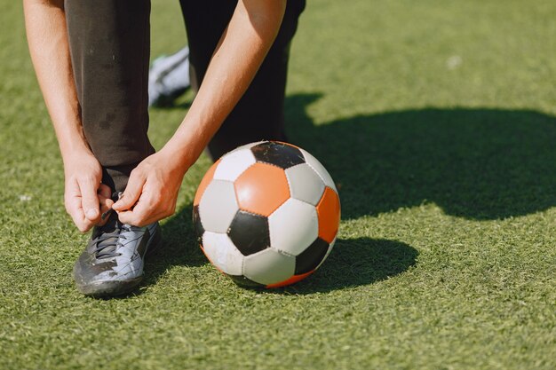 El hombre juega socerl en el parque. Torneo de mini-fútbol. Chico en trajes deportivos negros.