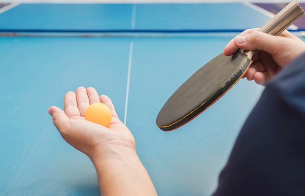Un hombre juega tenis de mesa listo para servir.