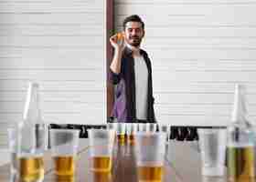 Foto gratuita hombre jugando al beer pong en una fiesta interior