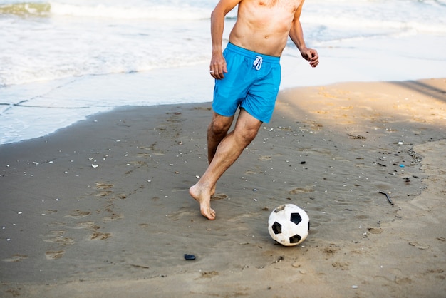 Foto gratuita hombre jugando al fútbol en la playa