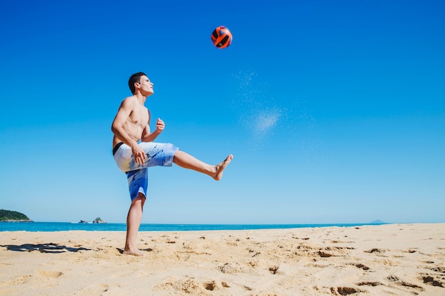 Hombre jugando al fútbol bajo el sol