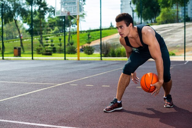 Hombre jugando baloncesto en la cancha del parque