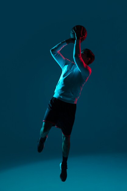 Hombre jugando baloncesto con luces frías