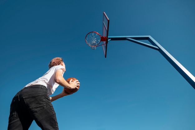 Hombre jugando baloncesto vista inferior