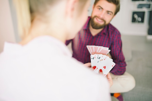 Hombre jugando a las cartas con novia