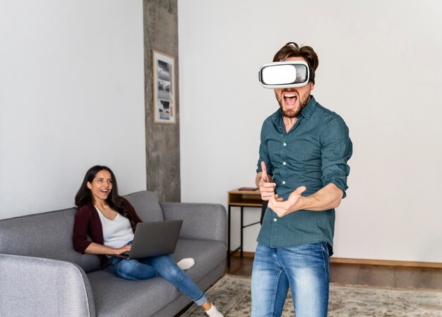 Hombre jugando con casco de realidad virtual en casa