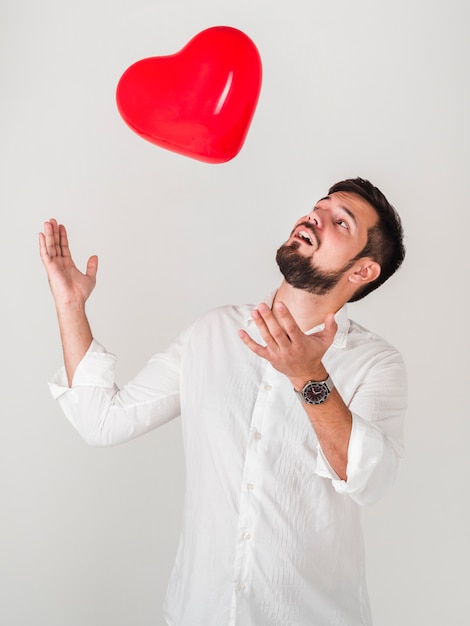 Hombre jugando con globos de san valentín