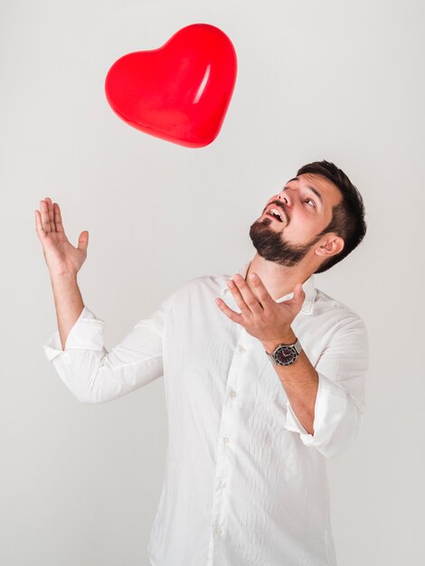 Hombre jugando con globos de San Valentín