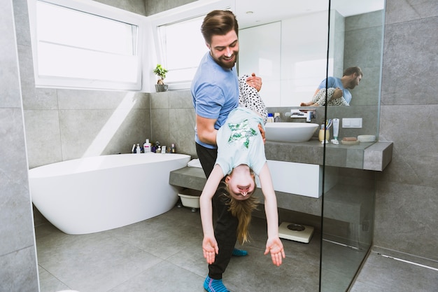 Hombre jugando con hija en el baño