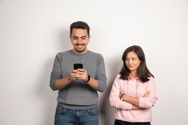 Hombre jugando con su teléfono mientras mira a su amante.