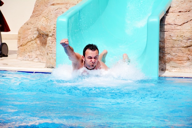 Hombre jugando en el tobogán de agua