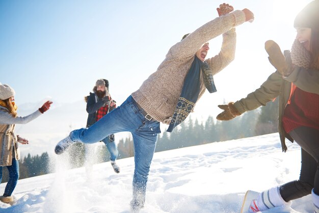 Hombre juguetón con tripulación en la nieve.