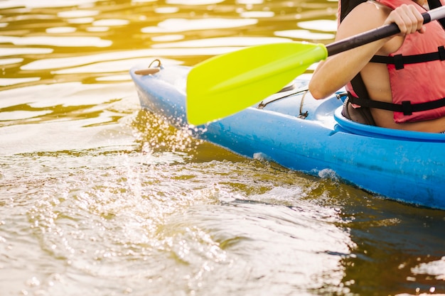 Hombre kayak con paleta en el lago