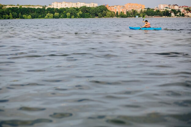 Un hombre en kayak en la superficie ondulada del agua del lago