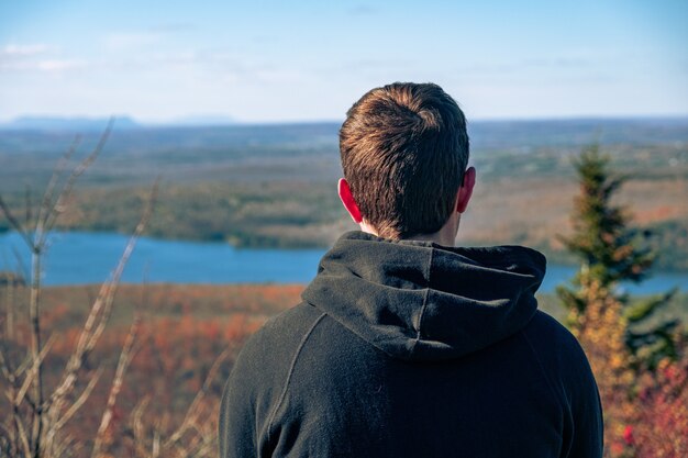 Hombre l mirando un hermoso paisaje fluvial en un día soleado