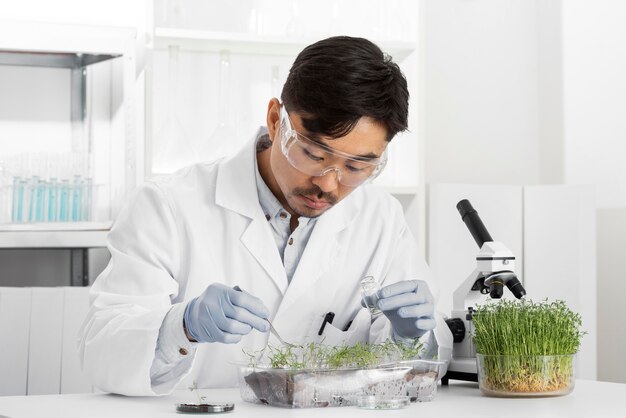 Hombre en laboratorio haciendo experimentos sobre brotes