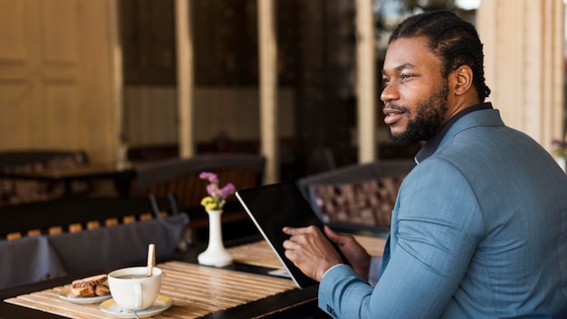 Hombre de lado comprobando su tableta con espacio de copia