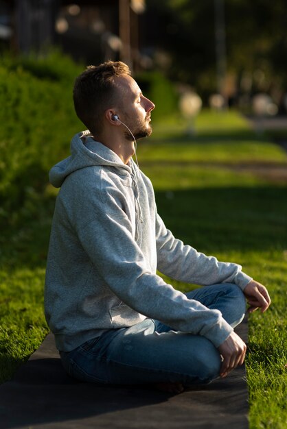 Hombre de lado meditando en la playa