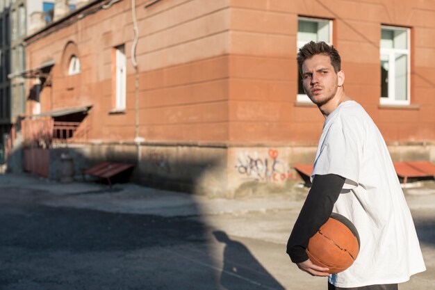 Hombre de lado con una pelota de baloncesto