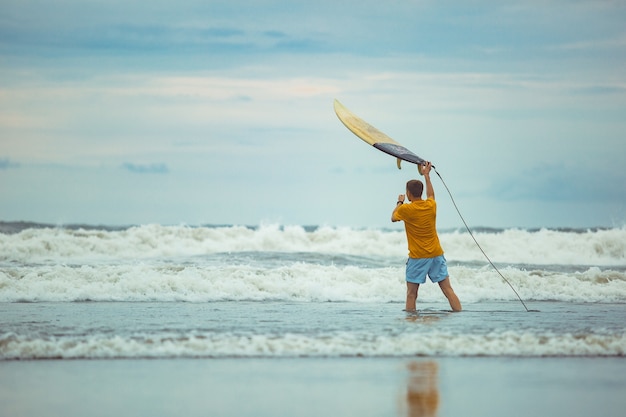 Un hombre lanza una tabla de surf a la cima.