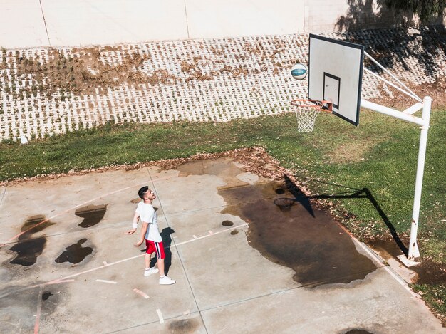 Hombre lanzando baloncesto en el aro