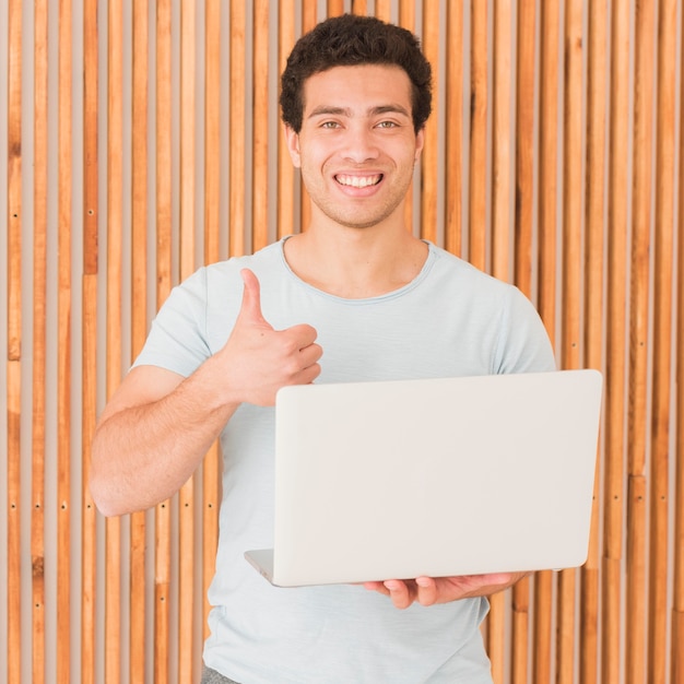 Hombre con laptop pulgares arriba gesto