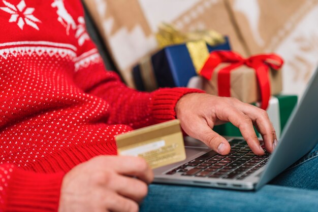 Hombre con laptop y tarjeta plástica