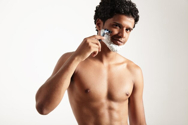 El hombre latino se está afeitando