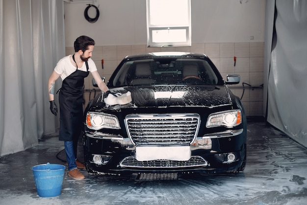 Hombre lavando su auto en un garaje