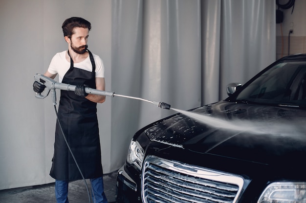 Hombre lavando su auto en un garaje