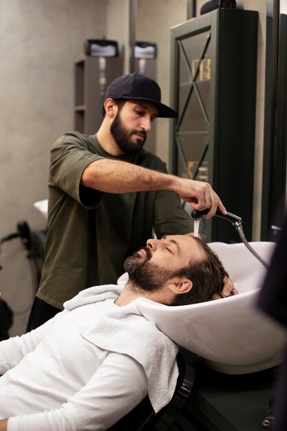 Hombre lavando su cabello en la peluquería