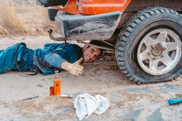 Foto gratuita el hombre se levanta en un camión 4x4 fuera de carretera