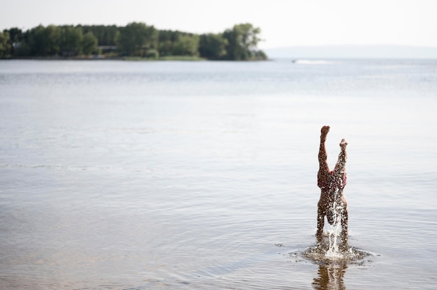 Foto gratuita hombre levantando las manos en el lago