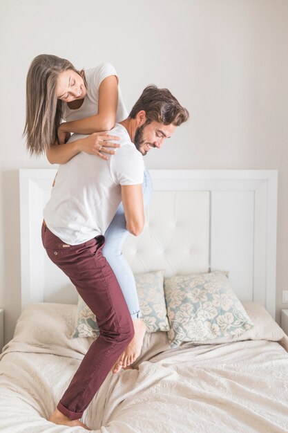 Hombre levantando a mujer en la cama