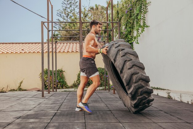 Hombre levantando rueda de tractor