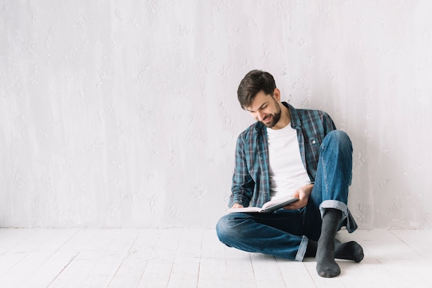 Hombre leyendo cerca de la pared