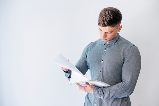 Foto gratuita hombre leyendo de cuaderno en estudio